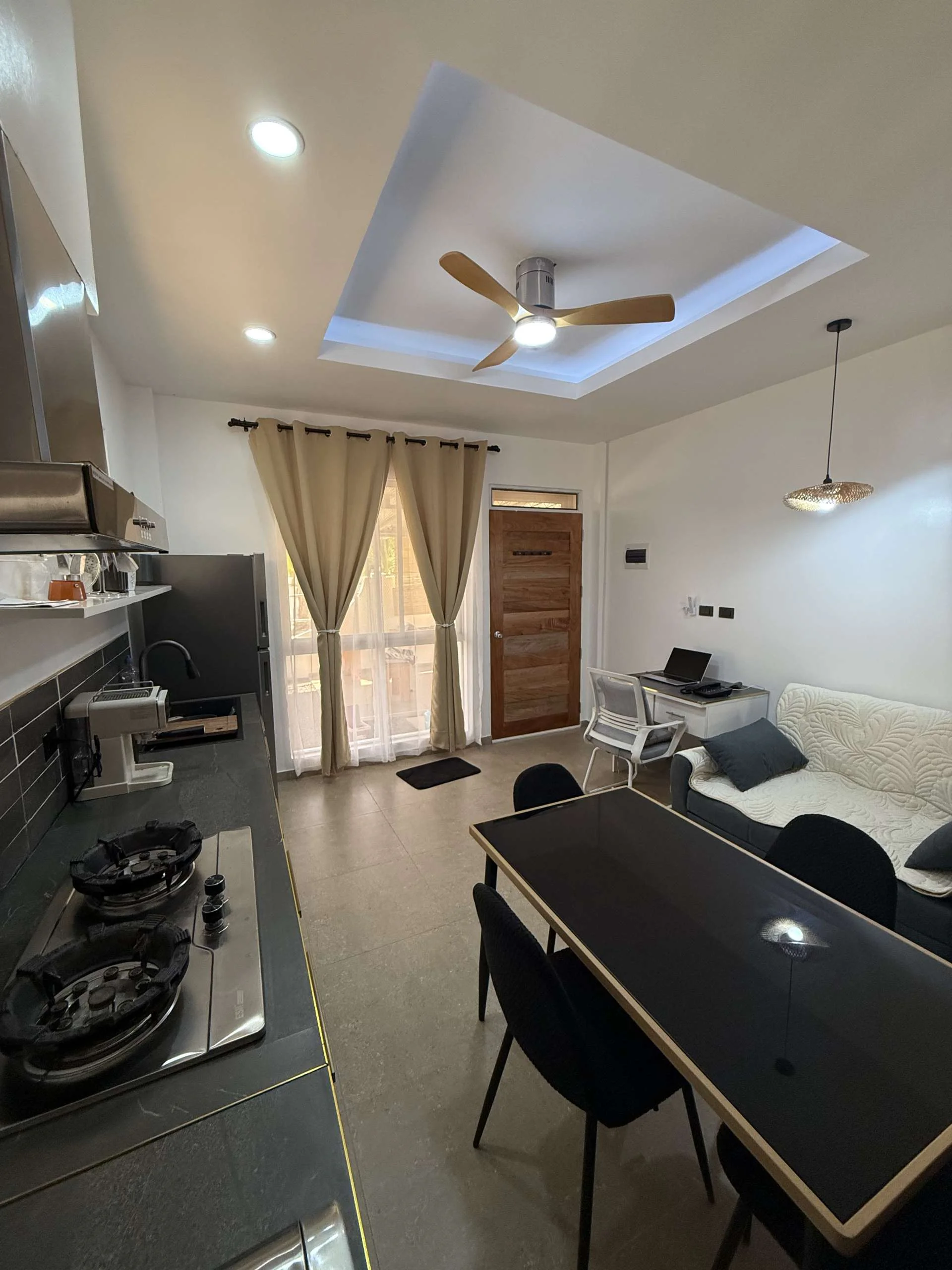 Living room and kitchenette in Papaya Apartment at Hero House Bantayan