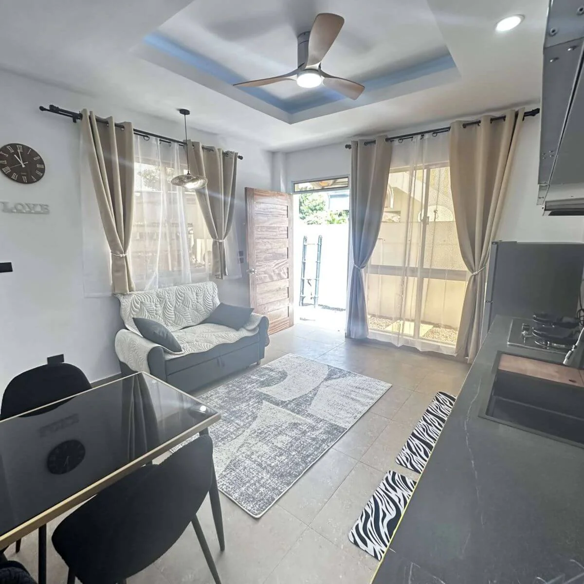Spacious open-plan kitchen with a table and sofas at the Hero House Bantayan Mango apartment.