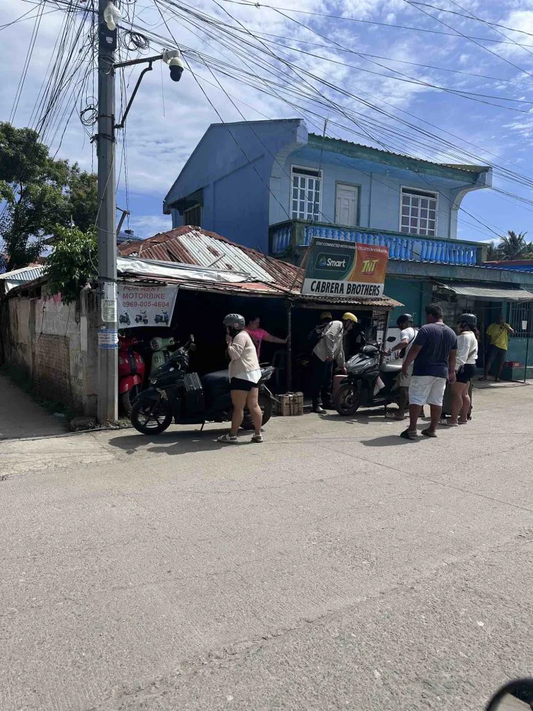 To the right of the port exit, there is one of these motorbike rental shops; notice the young woman renting a bike with her trolley.
