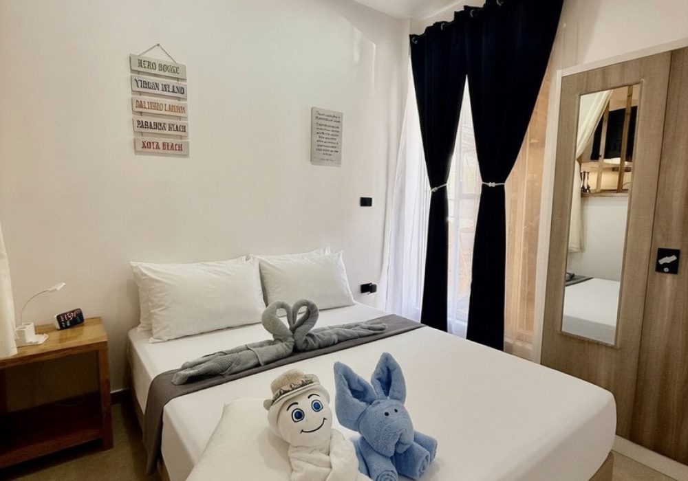 Romantic double bedroom with towel swans at Hero House apartment in Santa Fe, Bantayan Island